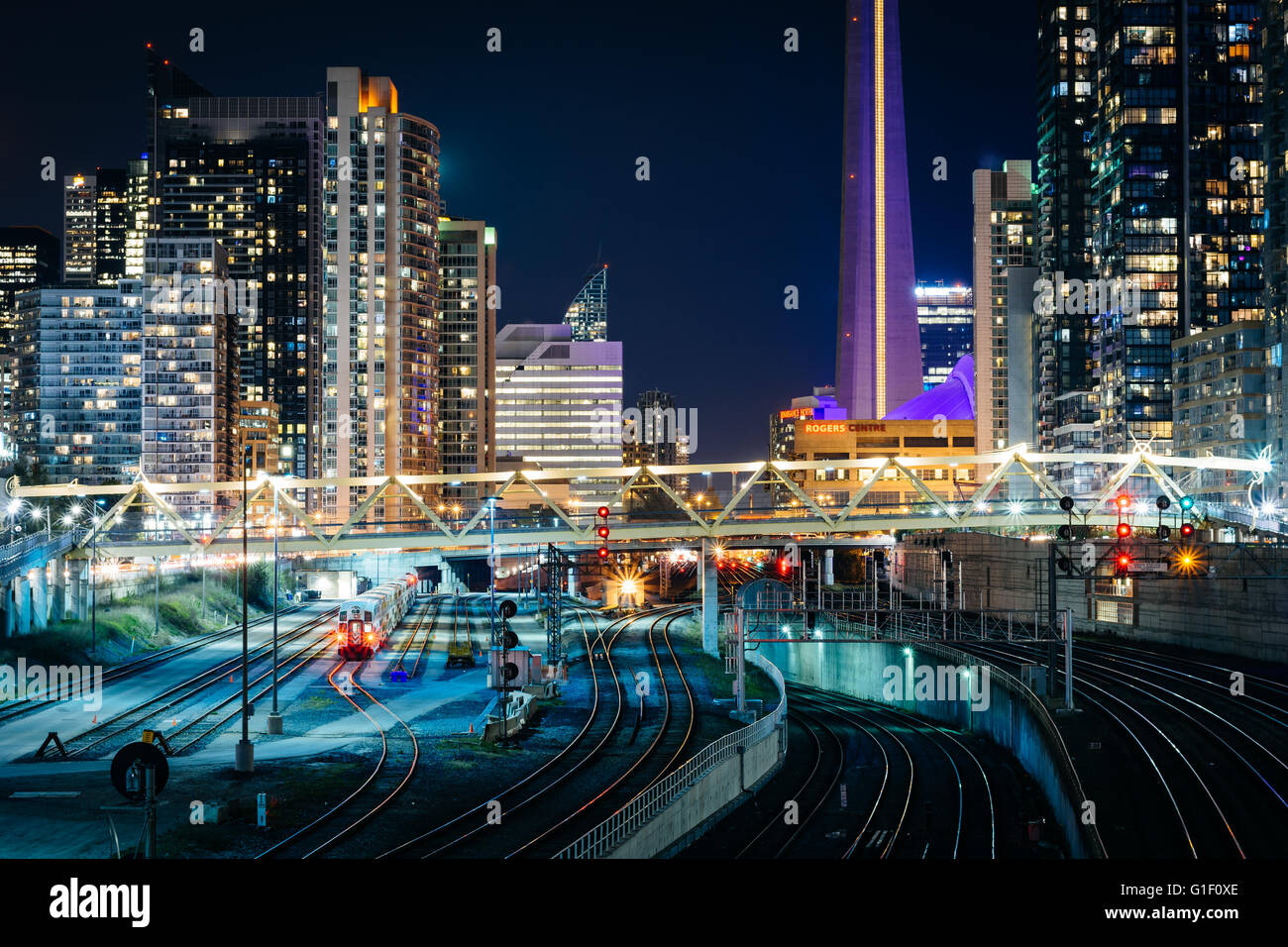 Vista dei binari della ferrovia e edifici moderni nel centro di notte, da Bathurst Street Bridge a Toronto, Ontario. Foto Stock