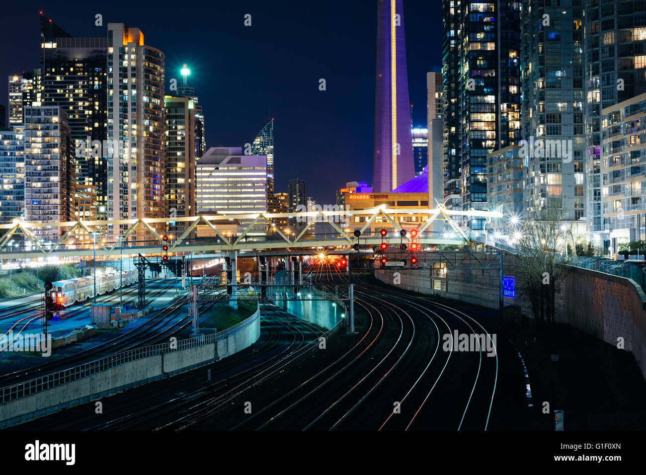Vista dei binari della ferrovia e edifici moderni nel centro di notte, da Bathurst Street Bridge a Toronto, Ontario. Foto Stock
