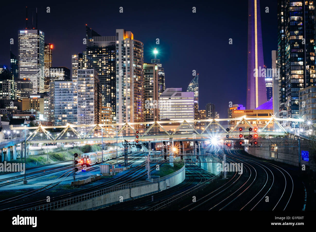 Vista dei binari della ferrovia e edifici moderni nel centro di notte, da Bathurst Street Bridge a Toronto, Ontario. Foto Stock