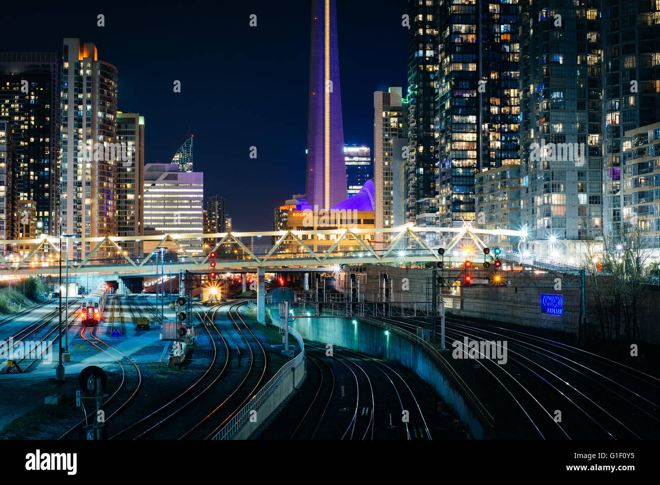 Vista dei binari della ferrovia e edifici moderni nel centro di notte, da Bathurst Street Bridge a Toronto, Ontario. Foto Stock