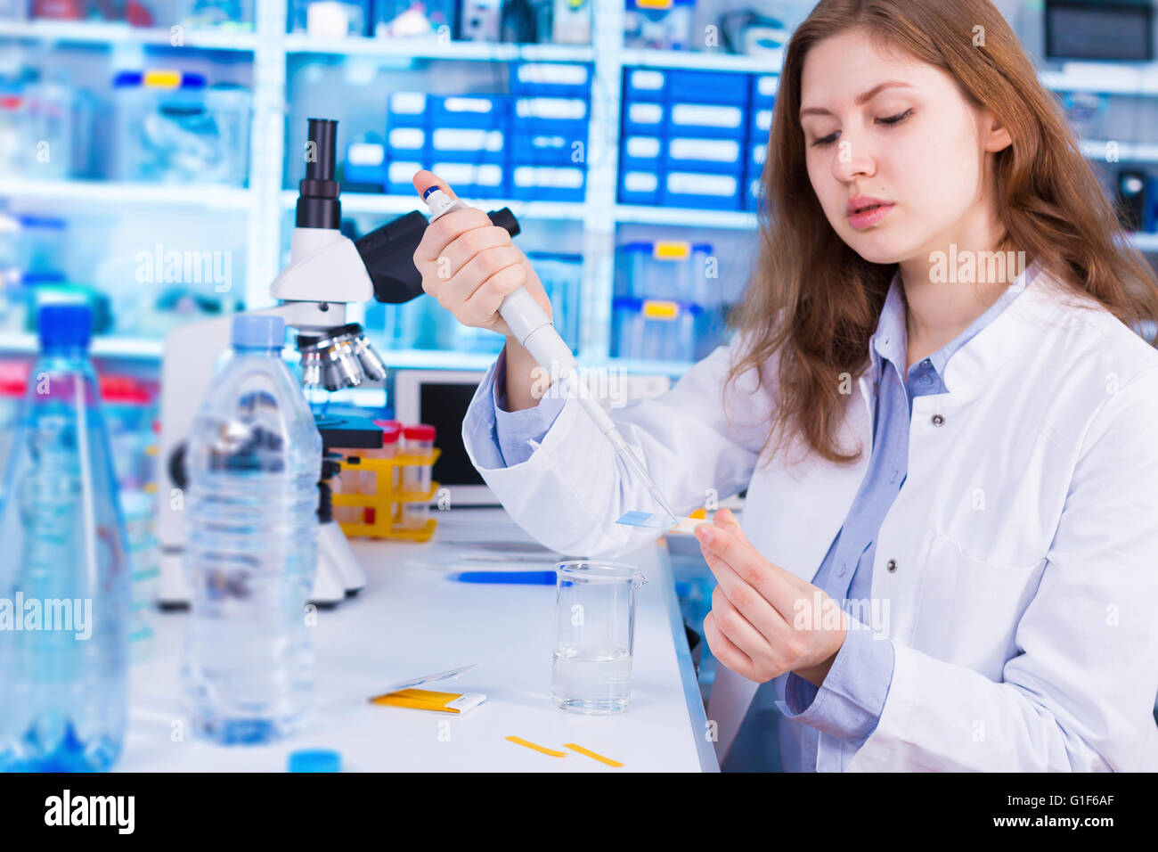 Modello rilasciato. Femmina tecnico di laboratorio acqua di test in laboratorio. Foto Stock