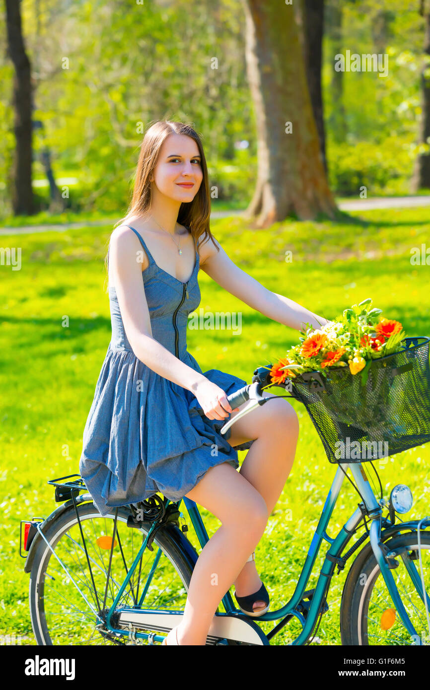 Modello rilasciato. Giovane donna bicicletta equitazione nel parco. Foto Stock