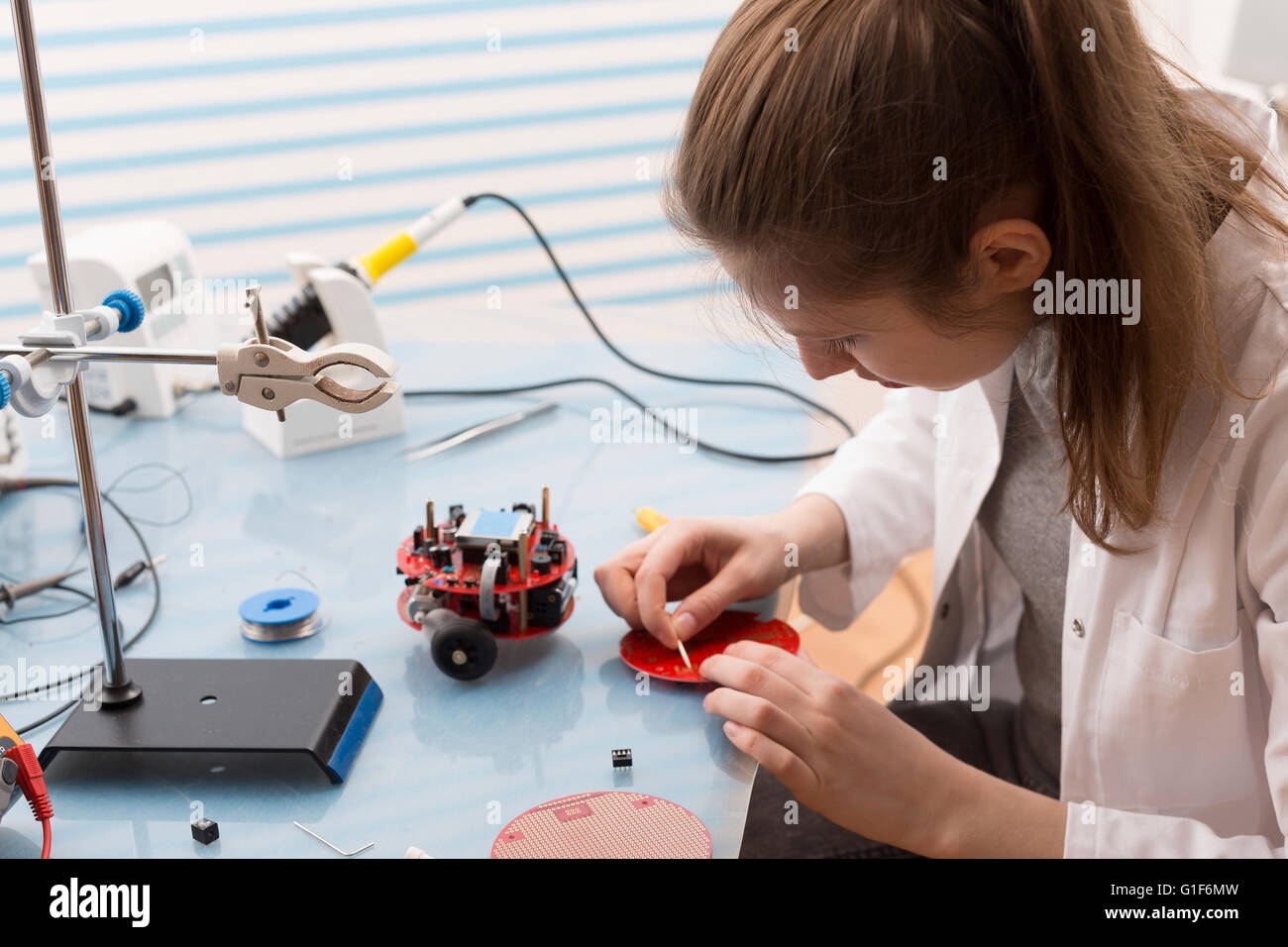 Modello rilasciato. Tecnico femminile lavora con apparecchiature elettriche in laboratorio. Foto Stock