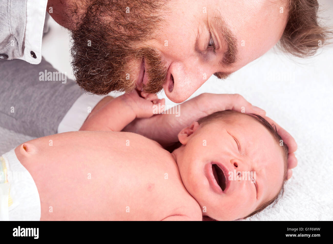 Modello rilasciato. Padre toccando neonato. Foto Stock