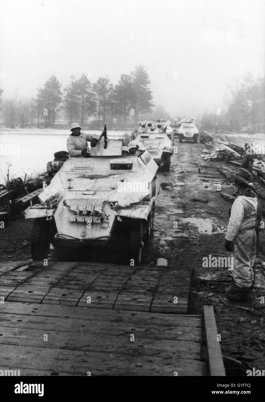 Il tedesco armatura 251 Halftracks in Snow camuffamento di attraversare un ponte stretto sul fronte orientale 1943 Foto Stock