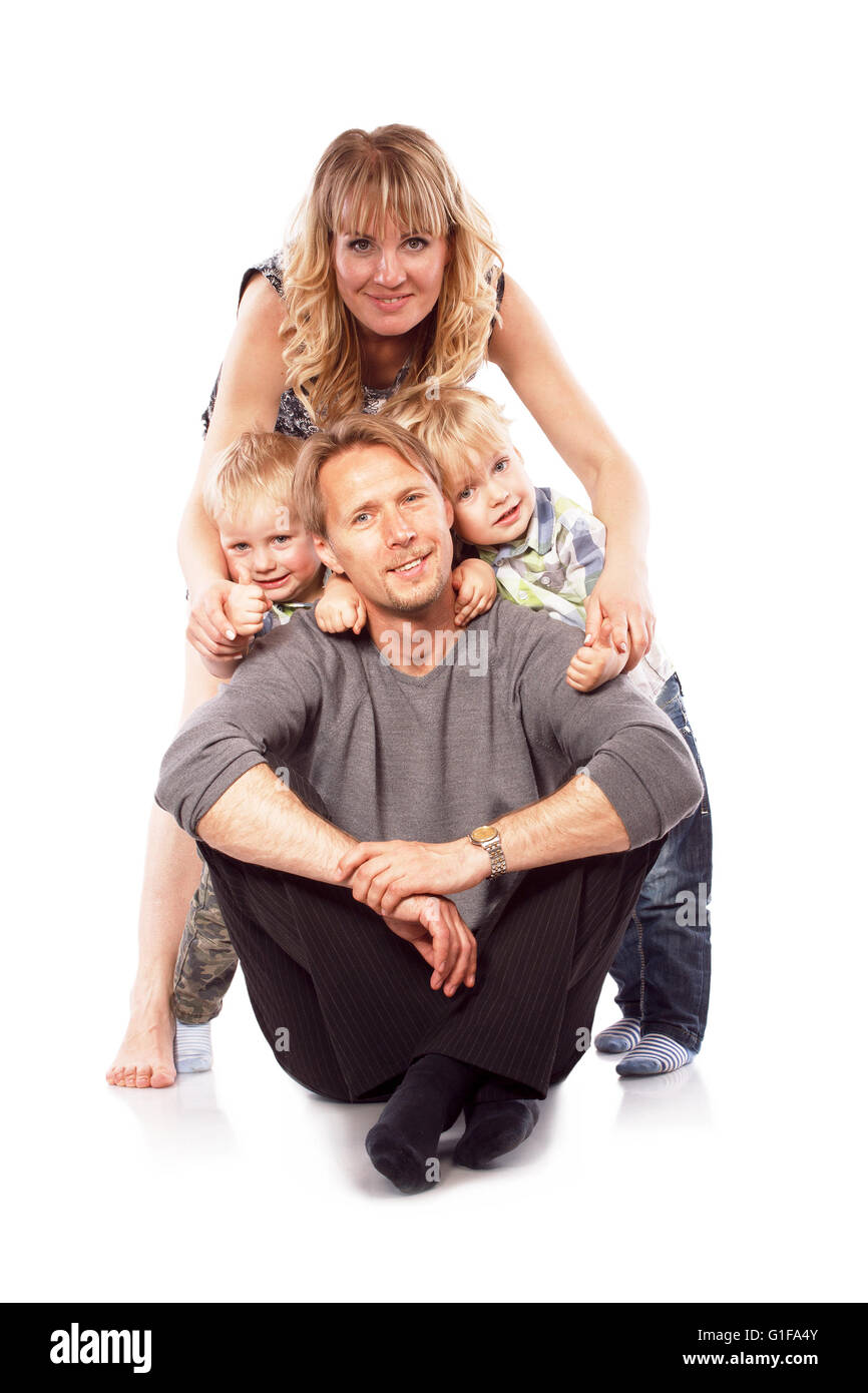 Caucasian sorridenti giovane famiglia con due bambini seduti sul pavimento. Isolato su bianco. Foto Stock