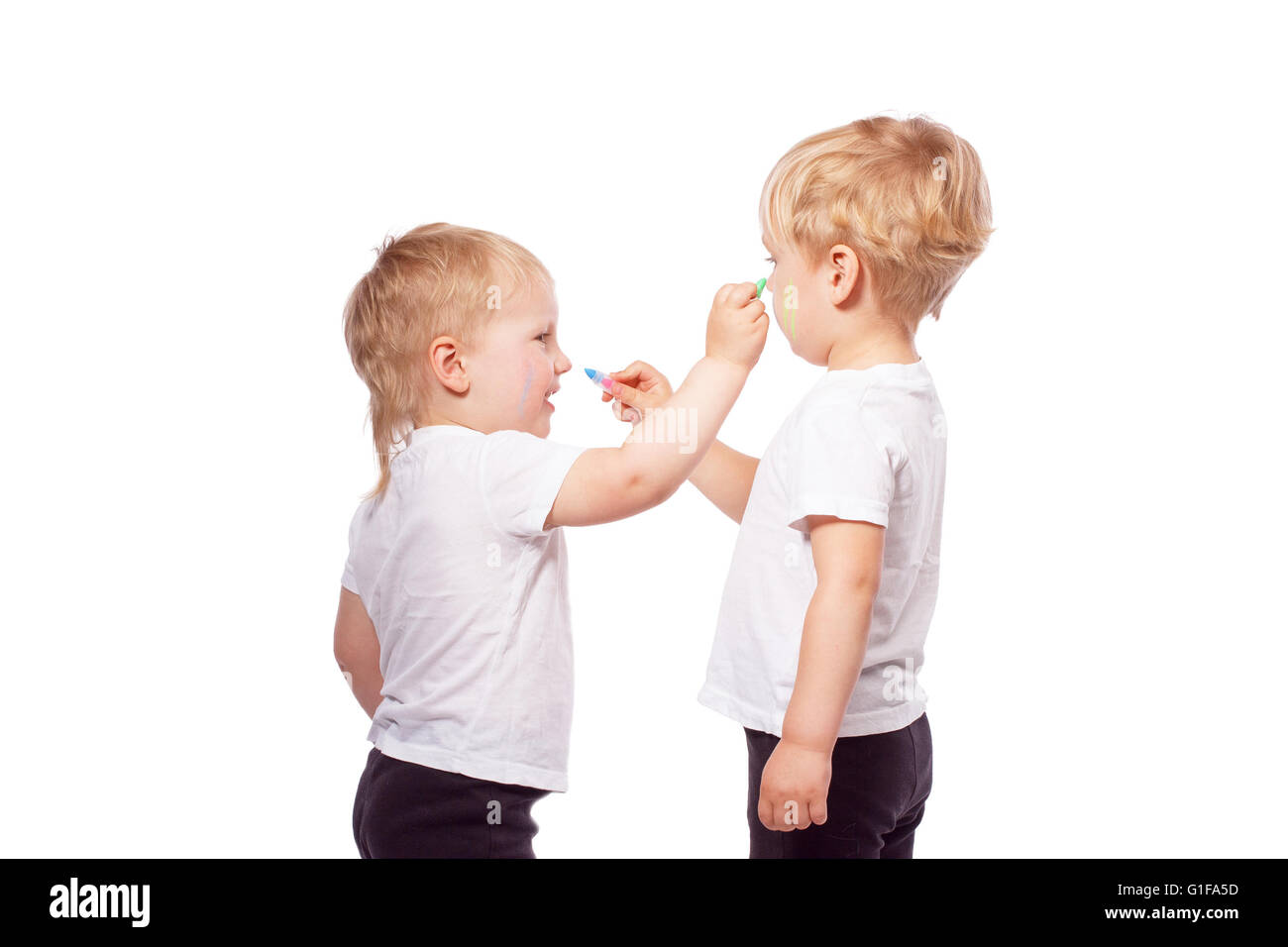 Bambini disegnare gesso colorato su ogni altra. Isolato su bianco Foto Stock