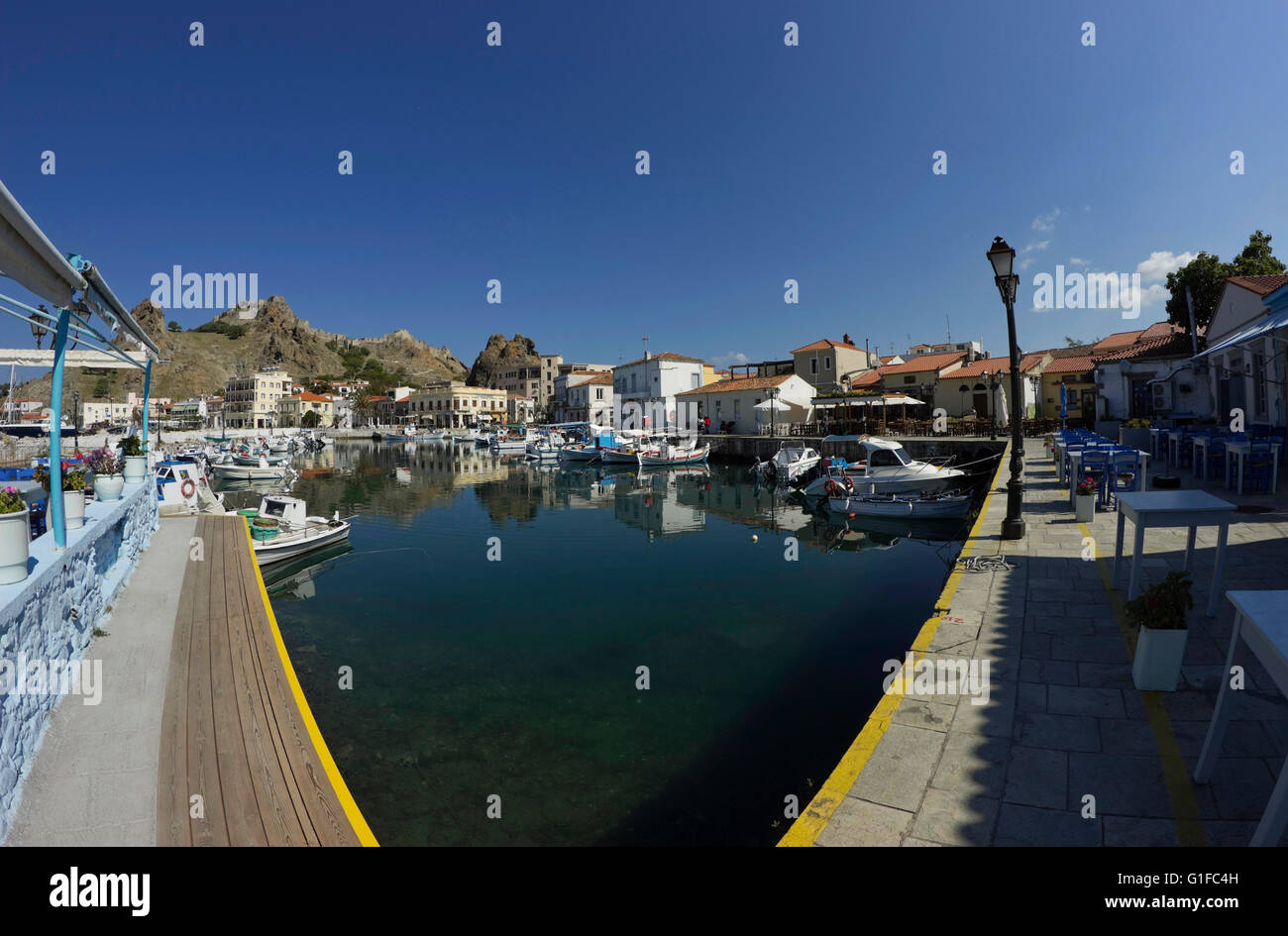 Vista fisheye del Mirina's Quay anchorage, la sua nuova costruzione in legno di accesso al dock di estensione e taverne. Limnos o Lemnos, Grecia Foto Stock