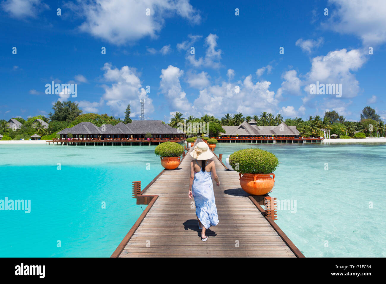 Donna sul molo Olhuveli Beach and Spa Resort South Male Atoll, Kaafu Atoll, Maldive Foto Stock