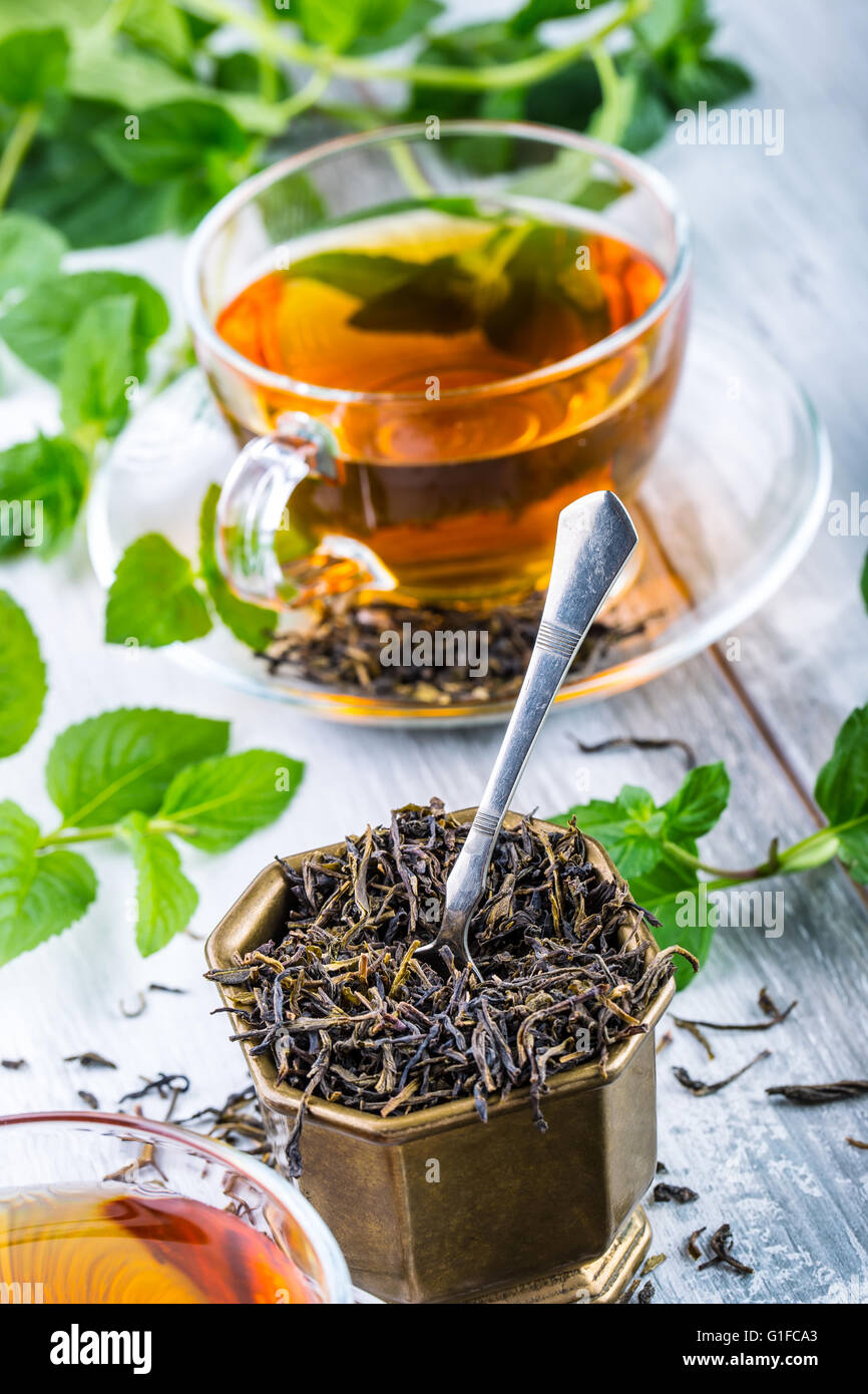 Il tè. Il tè alla menta. Il tè alle erbe. Foglia di menta. Le foglie di menta. Il tè in un bicchiere di vetro, foglie di menta, tè essiccate, fettine di lime. tè alle erbe e menta l Foto Stock
