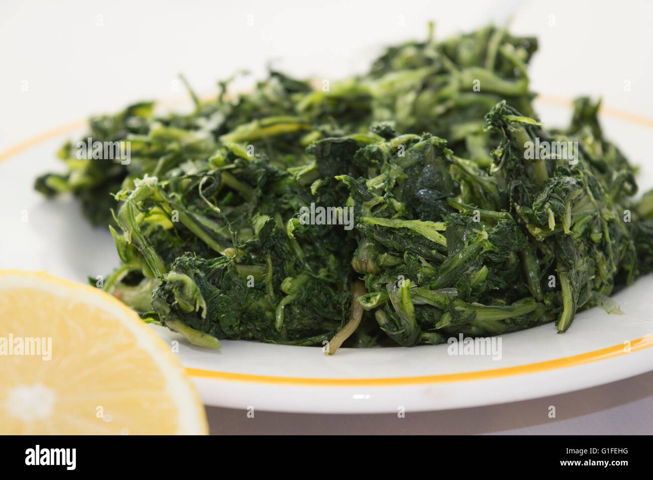 Scarola al vapore condito con olio di oliva e servite su un piatto bianco  Foto stock - Alamy