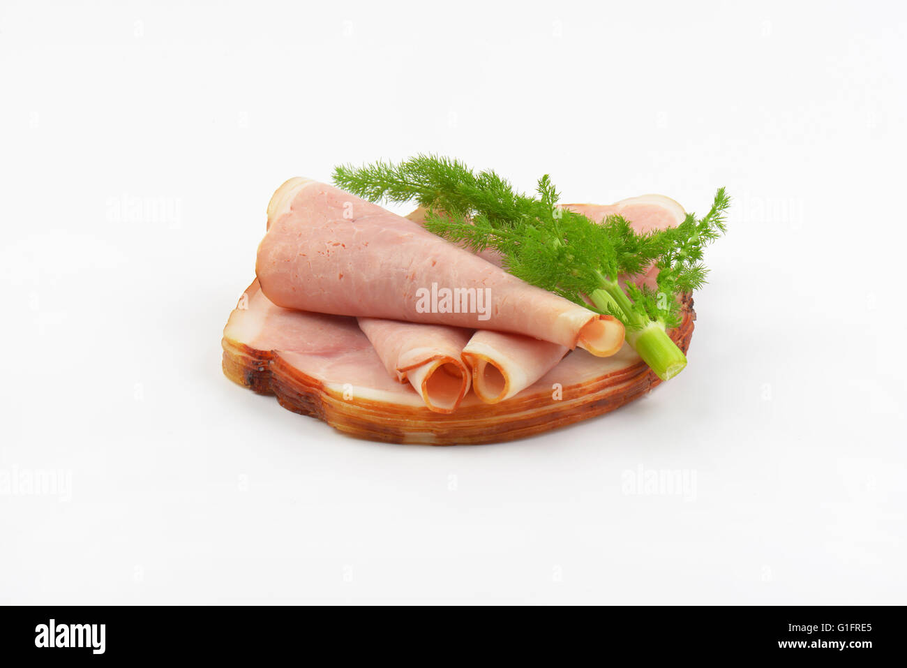 Pila di fette di prosciutto e aneto su sfondo bianco Foto Stock