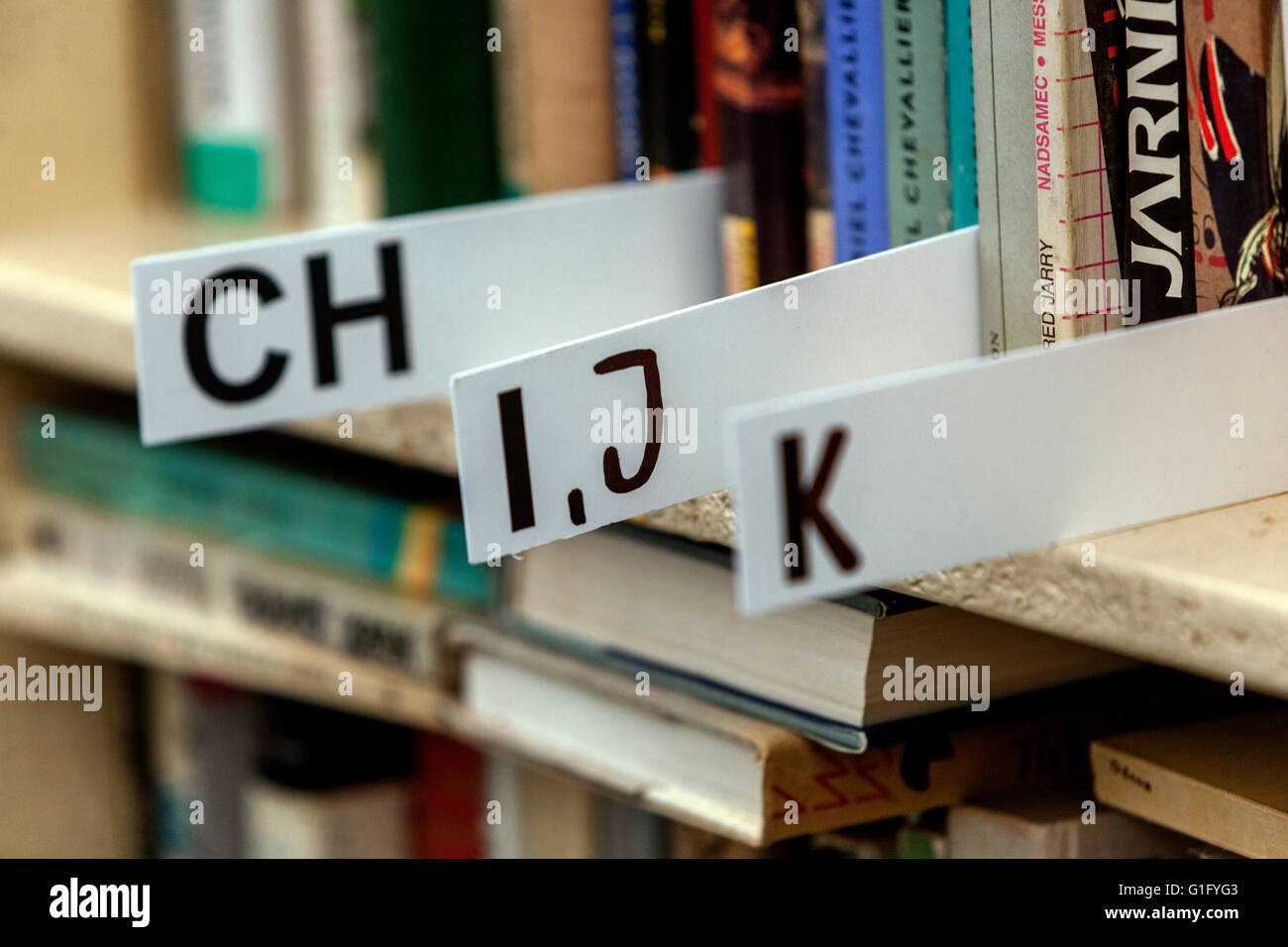 Ordinamento alfabetico dei libri giacenti sugli scaffali, libri della biblioteca sullo scaffale Foto Stock