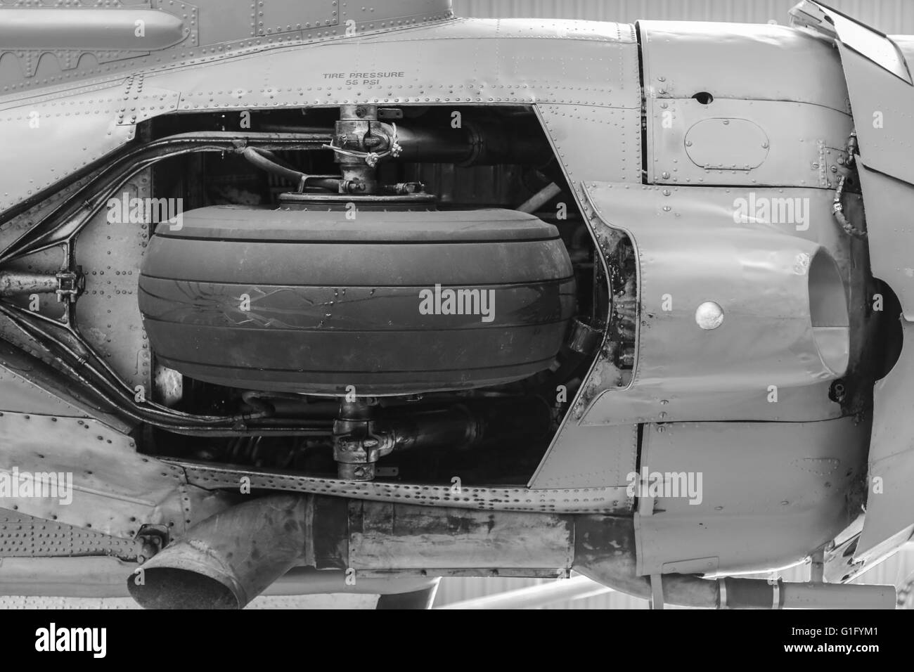 Un colpo dettagliato di una parte del carrello di atterraggio, ruota con pneumatico sul lato inferiore di un piano Foto Stock