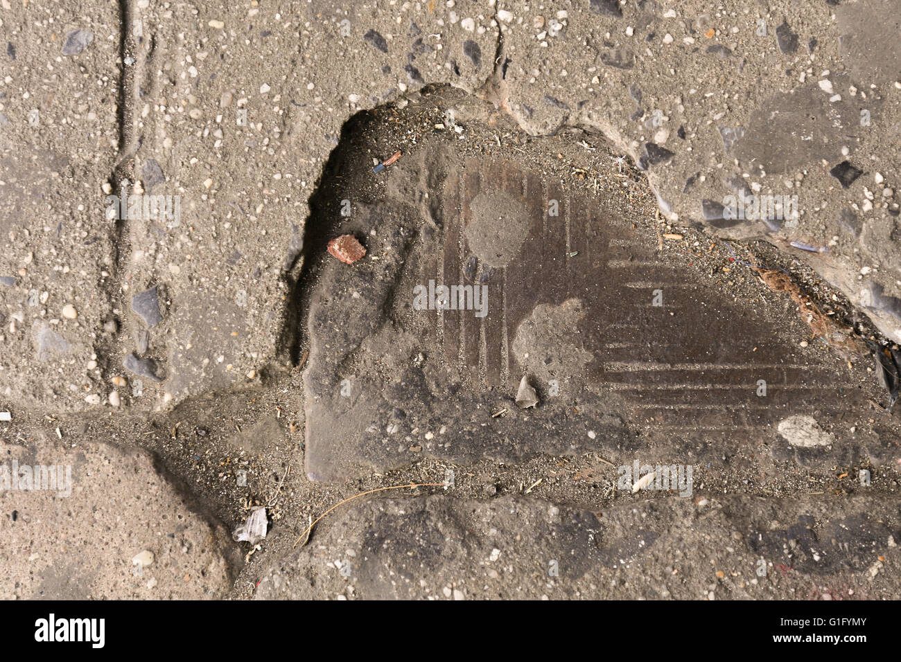 Scheggiati calcestruzzo rivelando una dettagliata la piastra di metallo al di sotto, urban fossile, New York CIty Foto Stock