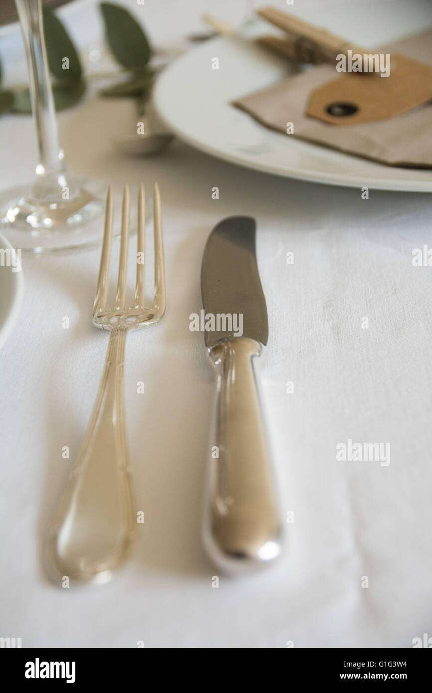 Le posate d'argento su un set tavolo con una tovaglia bianca Foto Stock