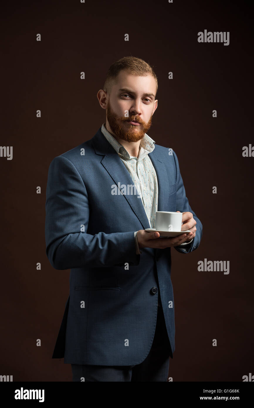 Elegante uomo barbuto con tazza di caffè Foto Stock
