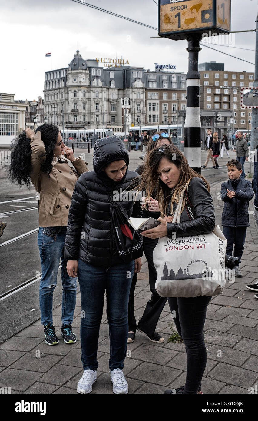 Due ragazze che studiano mappa alla fermata del tram di fronte la Stazione Centrale di Amsterdam Foto Stock