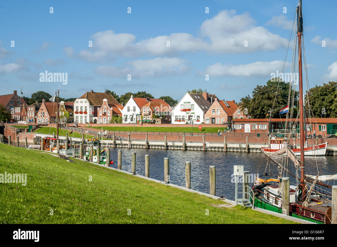 Case a Sielstrasse e barche nel porto di pesca di Greetsiel, Bassa Sassonia, Germania Foto Stock