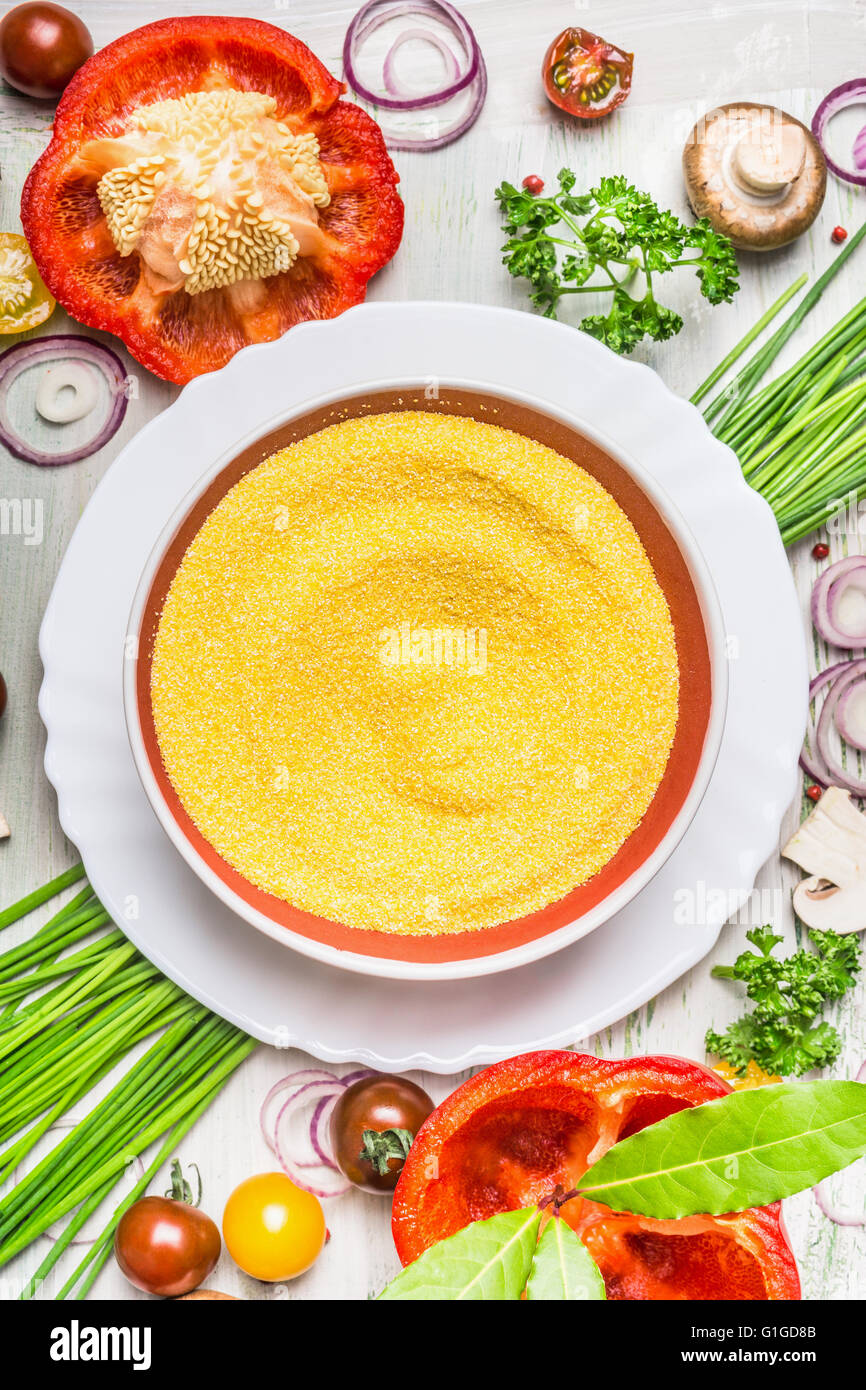 Piatto di polenta e varie verdure e condimenti per la gustosa cucina vegetariana su luce in legno rustico sfondo, Foto Stock