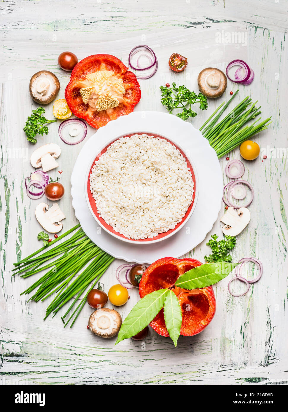 Risotto al piatto di riso e verdure varie e condimenti per la gustosa cucina vegetariana su luce in legno rustico Foto Stock