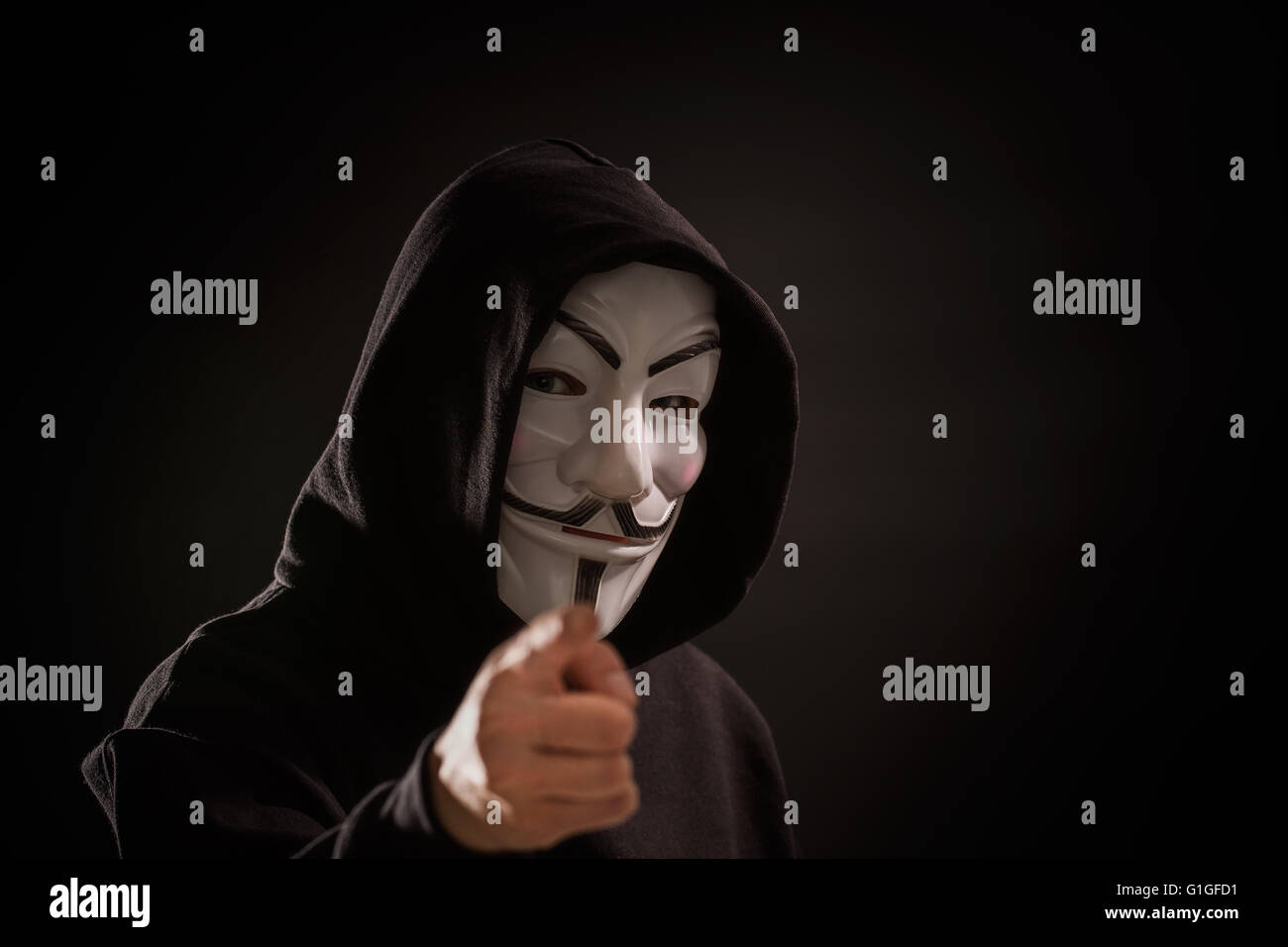 Bełchatow, Polonia - Dicembre 06, 2015: un uomo che indossa la maschera della Vendetta - simbolo per la online gruppo hacktivist anonimo. Backg nero Foto Stock