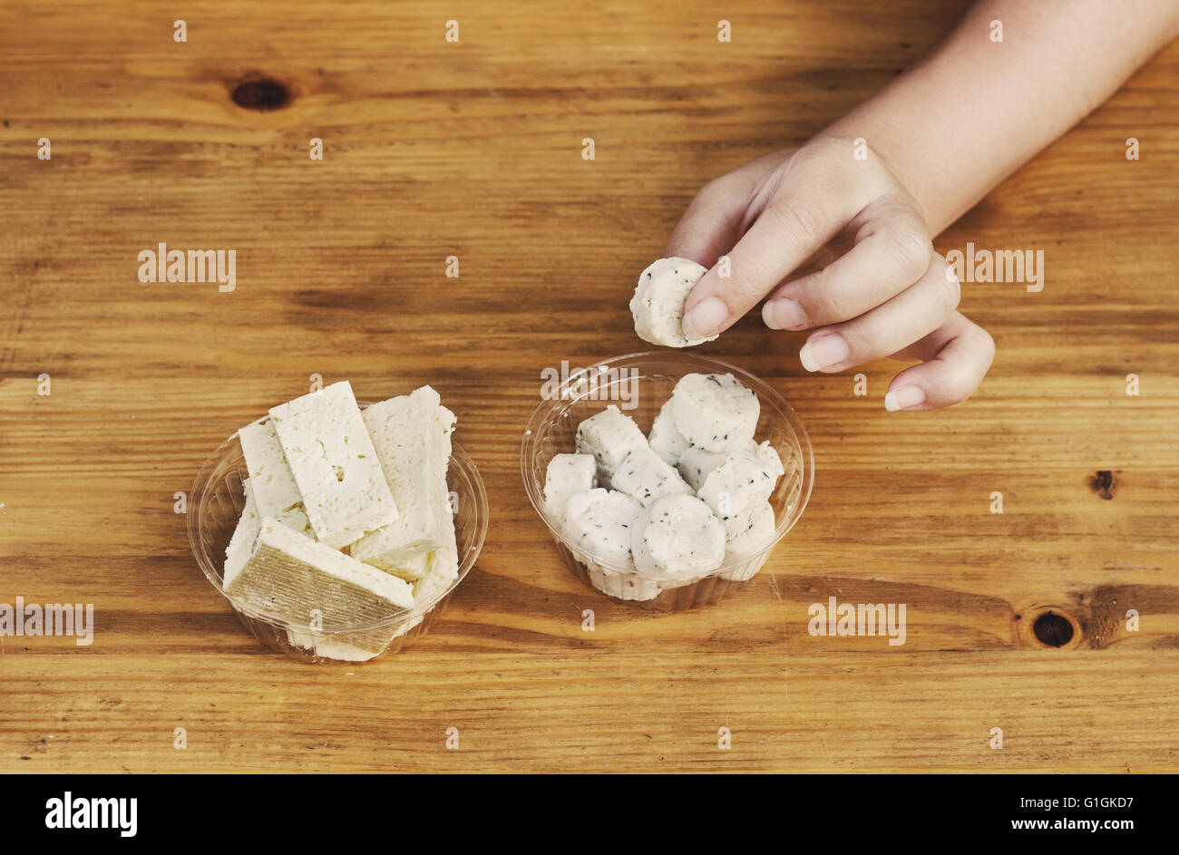 Ragazza prendere in mano una fetta di formaggio di pecora con potherbs Foto Stock