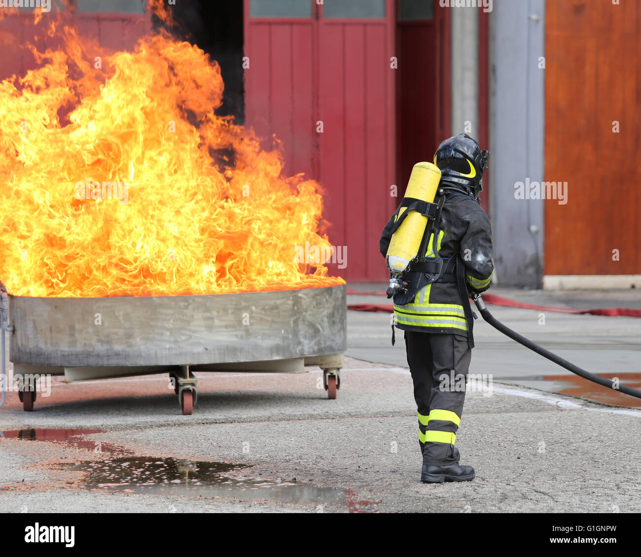 I vigili del fuoco con bombole ossigeno spegnere il fuoco durante un esercizio di formazione Foto Stock