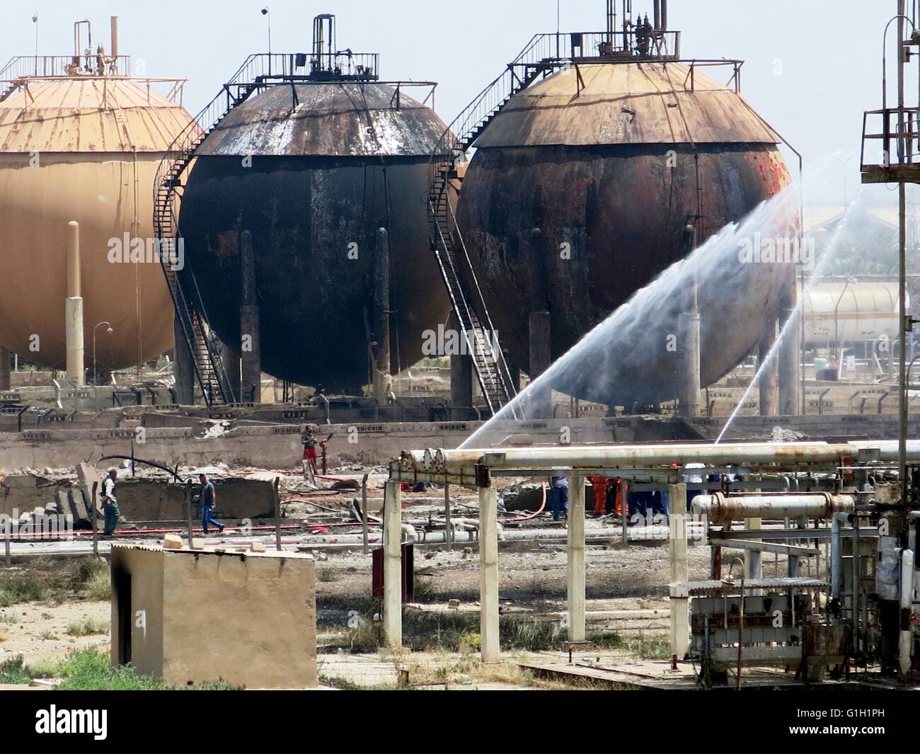 Baghdad, capitale irachena di Baghdad. 15 Maggio, 2016. Il lavoro dei vigili del fuoco in un impianto di gas dopo che esso è stato attaccato da uno Stato islamico (SI) attentatori suicidi, in zona Taji, periferia nord della capitale irachena di Bagdad, 15 maggio 2016. Fino a sette elementi di sicurezza e operai civili sono stati uccisi e 24 altri feriti domenica, come le forze di sicurezza irachene sventato un tentativo da parte di uno Stato islamico (SI) attentati suicidi a sequestrare e distruggere un impianto di gas in un sobborgo a nord di Bagdad, un ministero degli interni di detta sorgente. Credito: Khalil Dawood/Xinhua/Alamy Live News Foto Stock