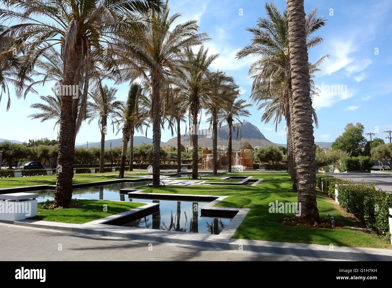 Le palme, la piscina e le montagne sull'isola di Creta, Grecia. Foto Stock