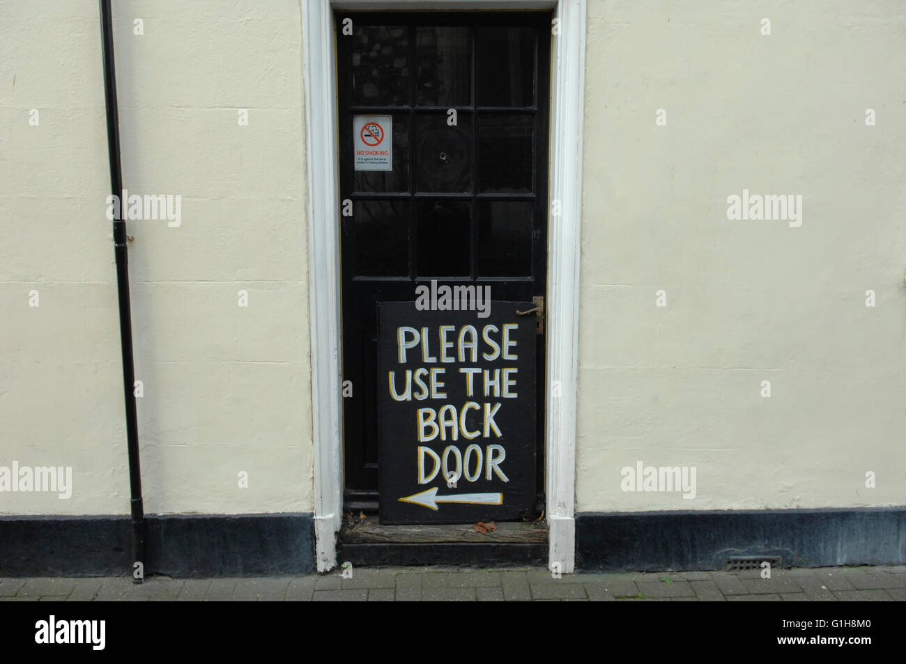 Una porta nera dichiarando di utilizzare la porta posteriore non in uso, Sandwich, Kent Foto Stock