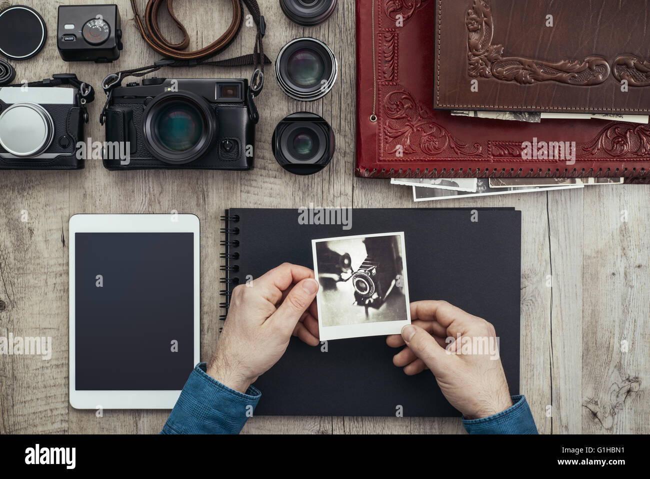 Attrezzature fotografiche, fotocamere digitali e PC tablet su un desktop  vintage, un fotografo è creare il suo album di foto Foto stock - Alamy
