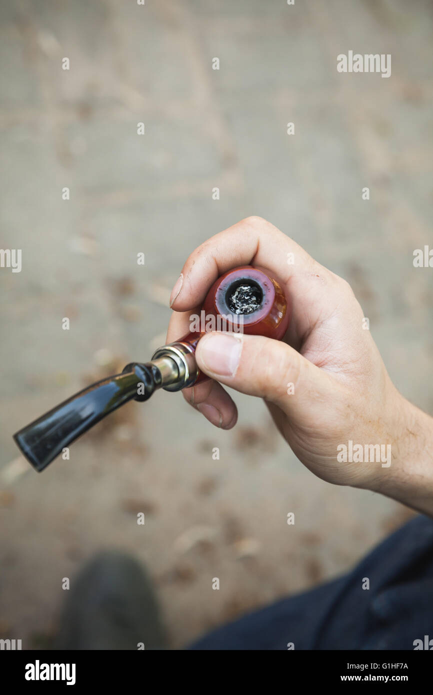 Tubo di fumo in mano maschio, vista dall'alto, outdoor foto con messa a fuoco selettiva e vintage correzione tonale filtro foto, vecchio stile FEP Foto Stock