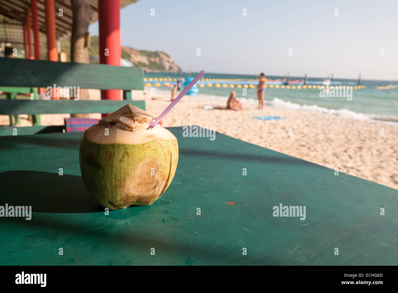 Freschi e deliziosi drink di noce di cocco sul tavolo verde vicino alla spiaggia Foto Stock