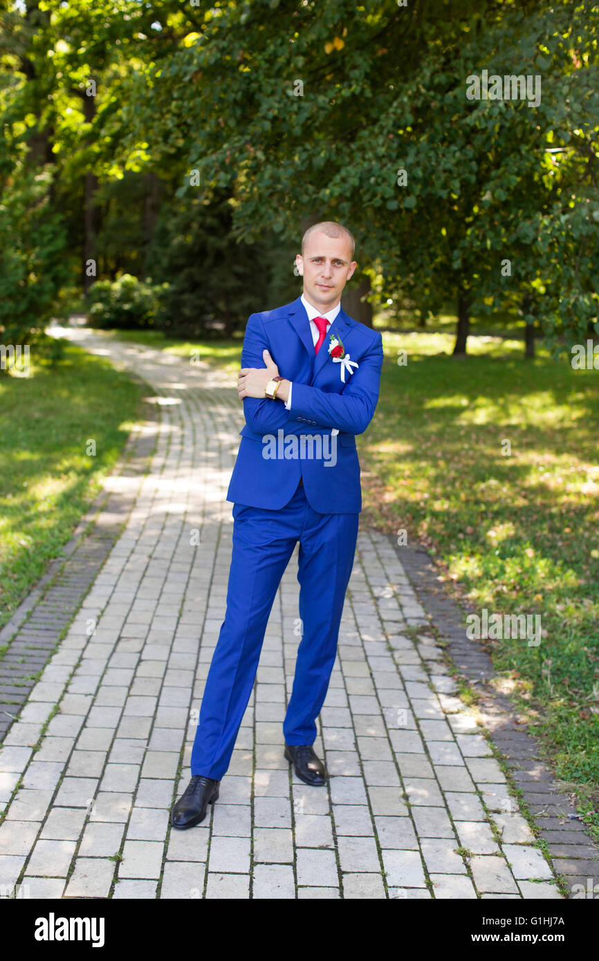 Lo sposo in una tuta blu in piedi in vicolo Foto Stock