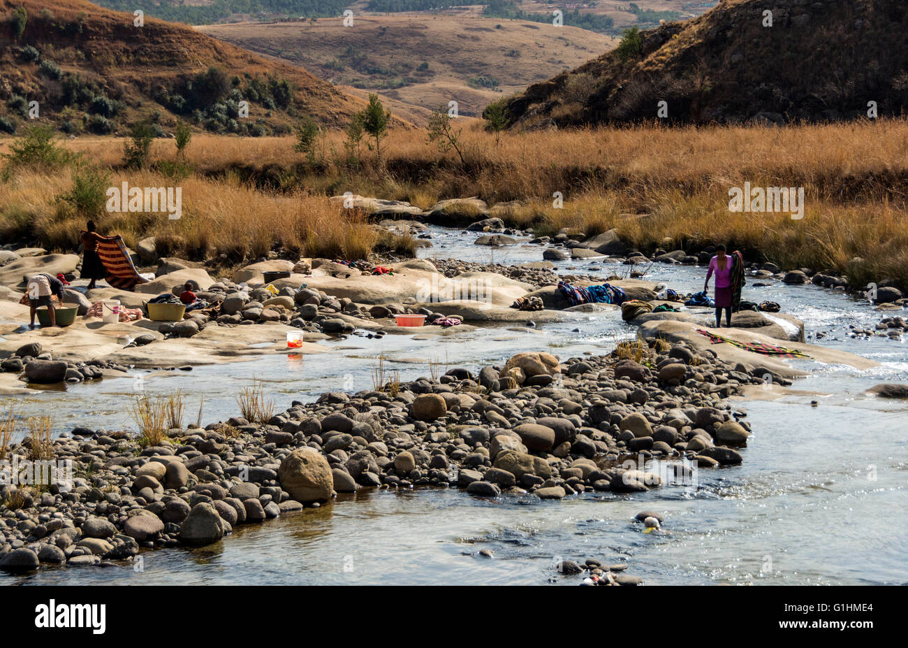 Il lavaggio della biancheria nel fiume in un villaggio ai piedi delle colline di Drakensbergs, KwaZulu Natal, Sud Africa Foto Stock