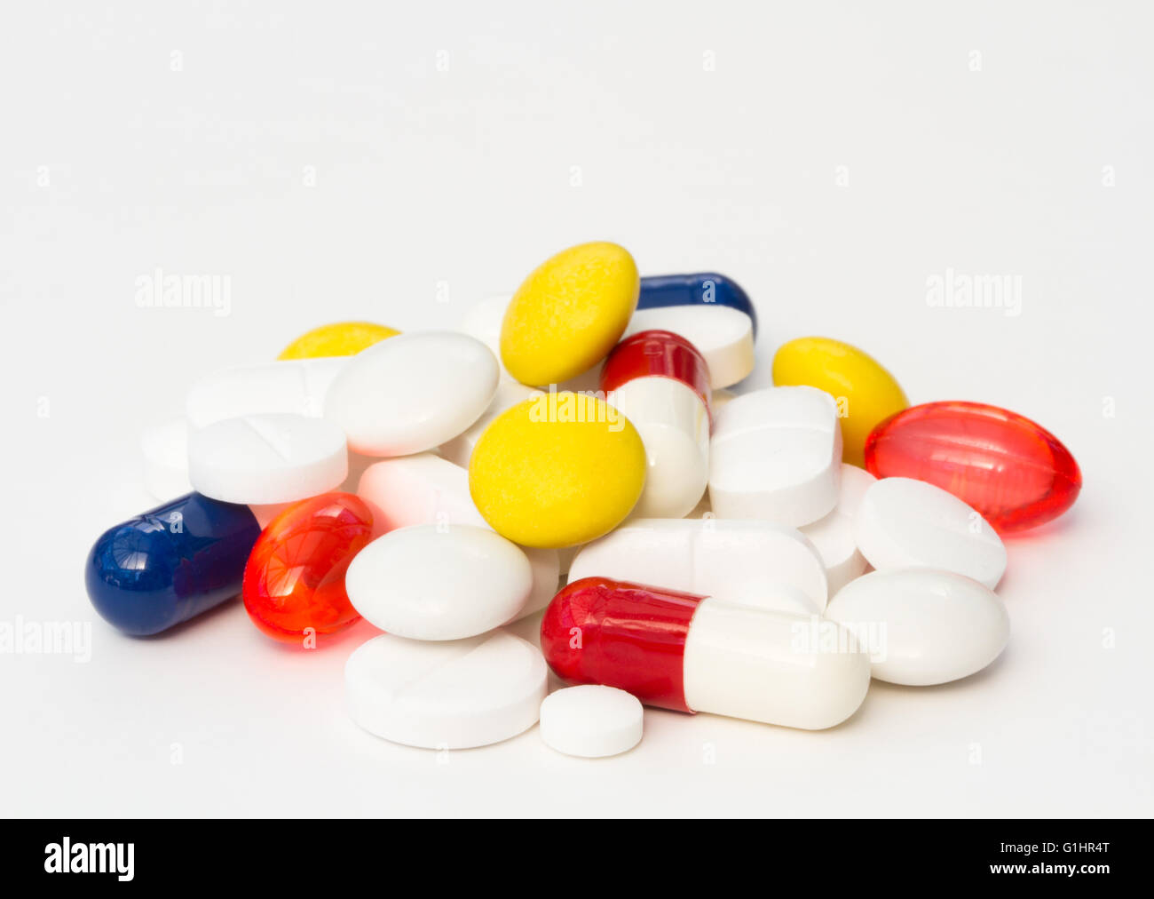 Un mucchio di differenti, varia e colorata pillole, compresse e farmaci isolato su un fondo bianco. Foto Stock