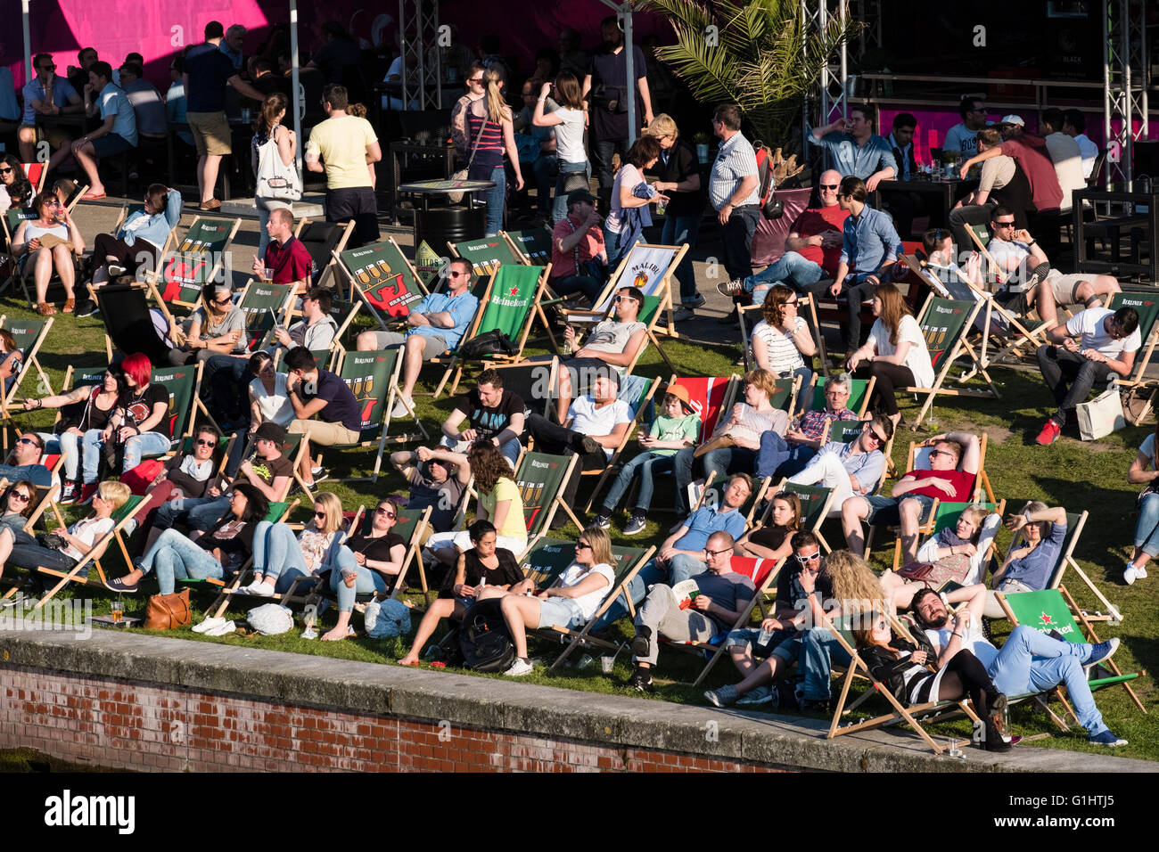 La gente seduta nel pomeriggio accanto al fiume Sprea a bar esterno a Berlino Germania Foto Stock