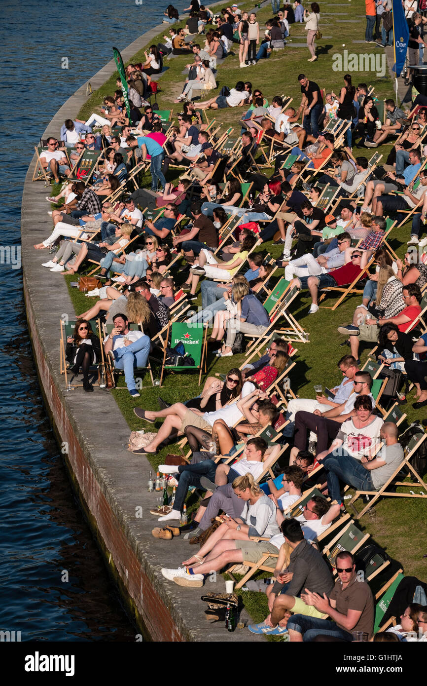 La gente seduta nel pomeriggio accanto al fiume Sprea a bar esterno a Berlino Germania Foto Stock