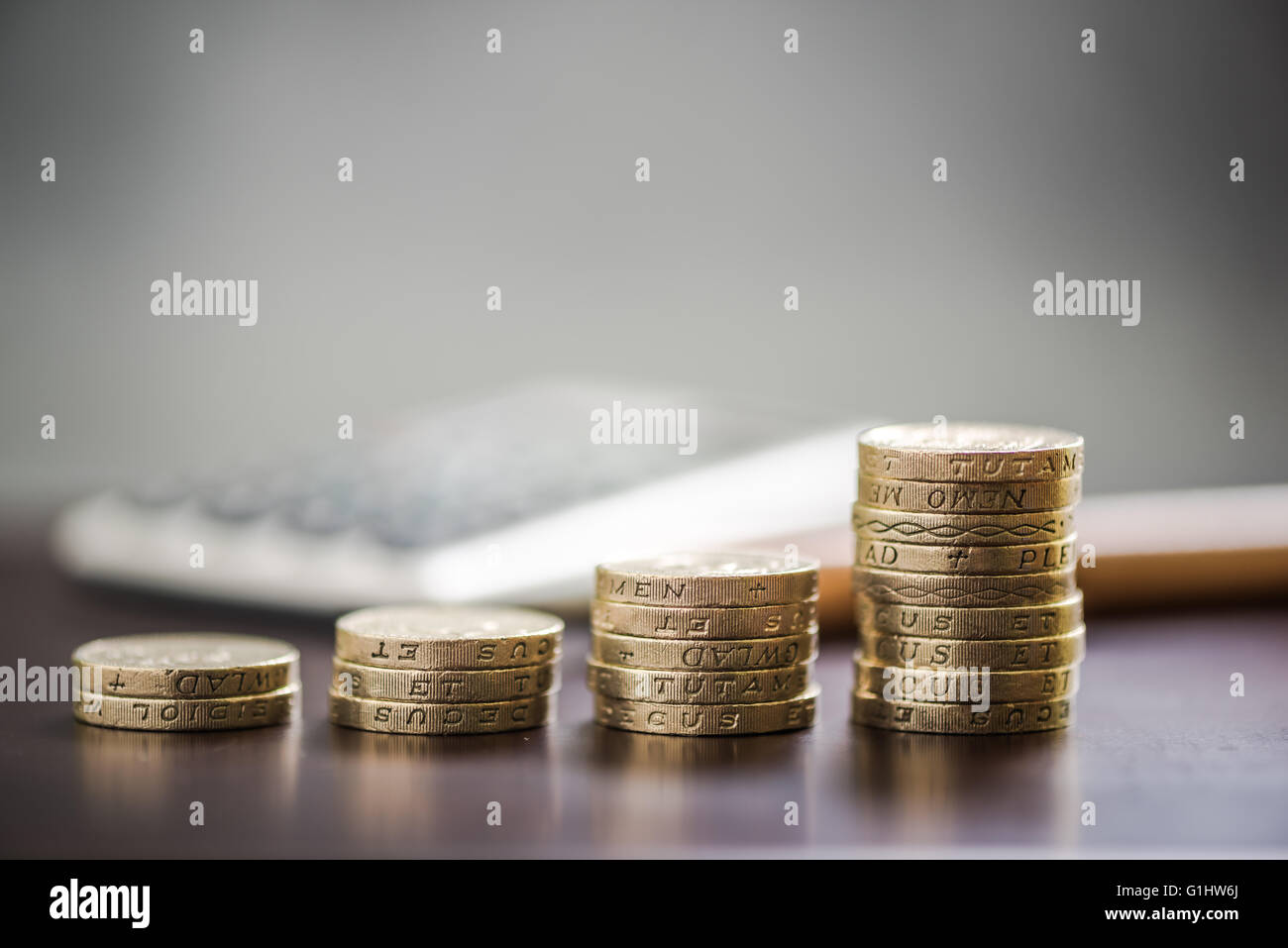 Pound coin pile, il concetto di crescita, sulla scrivania in ufficio Foto Stock
