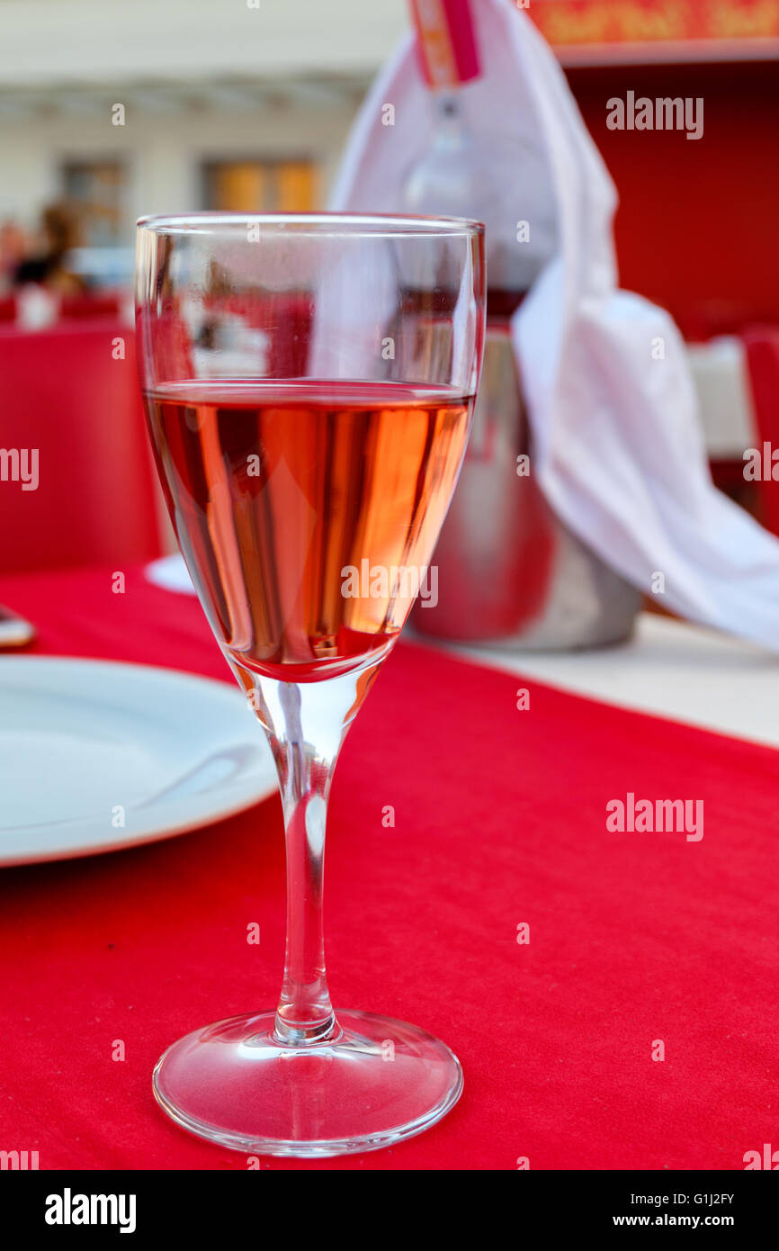 Red Rose vino in un bicchiere da vino Foto Stock