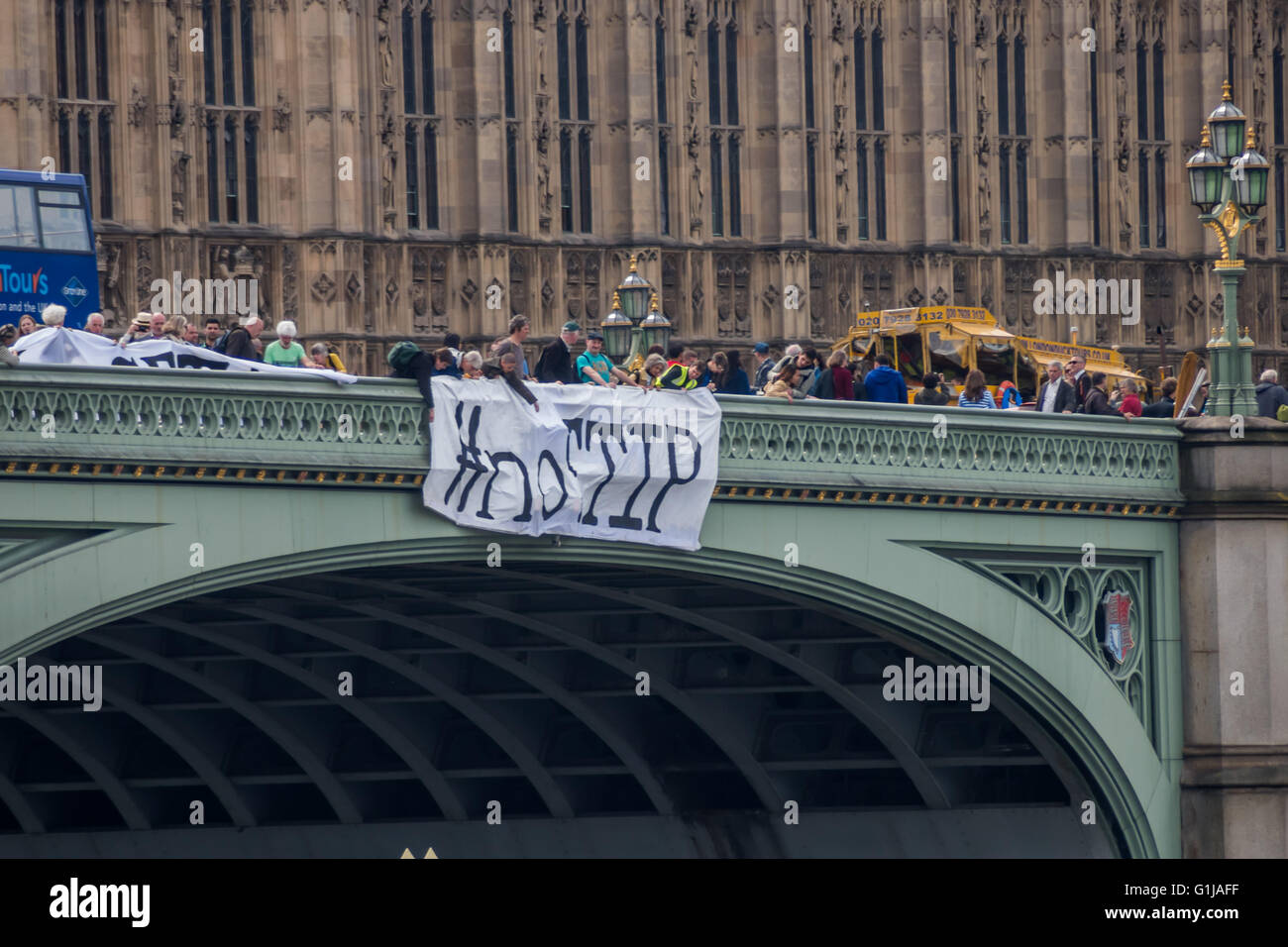 Londra, Regno Unito. 16 Maggio, 2016. Come parte di una giornata di protesta contro il Canada/UE e UA/UE trattative commerciali in corso di negoziato in segreto, attivisti banner abbassata sul Westminster Bridge con i messaggi '#noCETA #noTTIP' e '#noCETA Hands Off la democrazia'. Anche i parlamentari che sono mantenuti al buio circa i dettagli di queste trattative e il parlamento del Regno Unito sarà quasi certamente non può essere consentito di votare su di essi; è la sola Unione europea Parlamento europeo che non è in grado di porre il veto CETA o TTIP. Peter Marshall / Alamy Live News Foto Stock