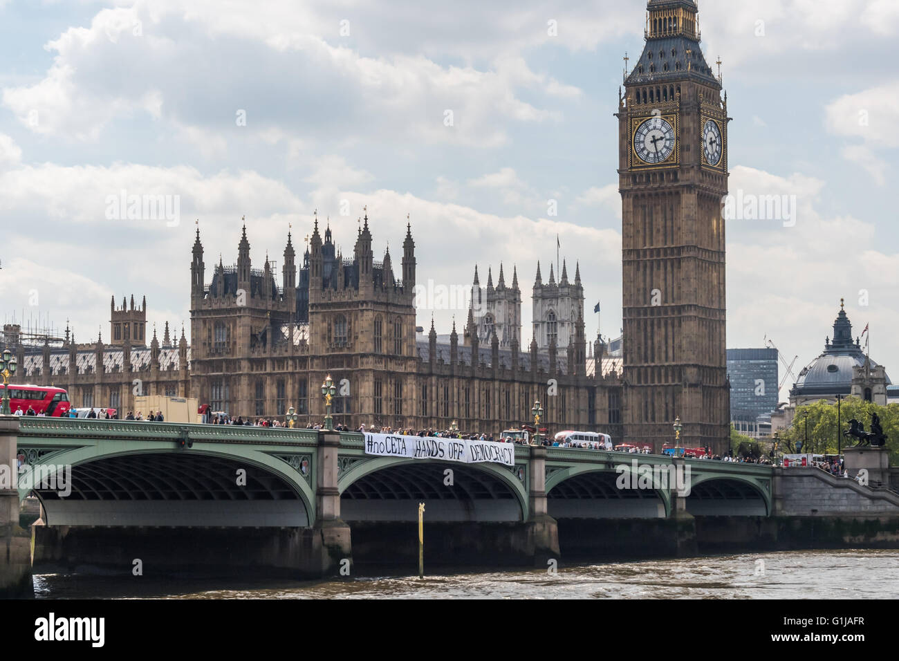 Londra, Regno Unito. 16 Maggio, 2016. Come parte di una giornata di protesta contro il Canada/UE e UA/UE trattative commerciali in corso di negoziato in segreto, attivisti banner abbassata sul Westminster Bridge con i messaggi '#noCETA #noTTIP' e '#noCETA Hands Off la democrazia'. Anche i parlamentari che sono mantenuti al buio circa i dettagli di queste trattative e il parlamento del Regno Unito sarà quasi certamente non può essere consentito di votare su di essi; è la sola Unione europea Parlamento europeo che non è in grado di porre il veto CETA o TTIP. Peter Marshall / Alamy Live News Foto Stock