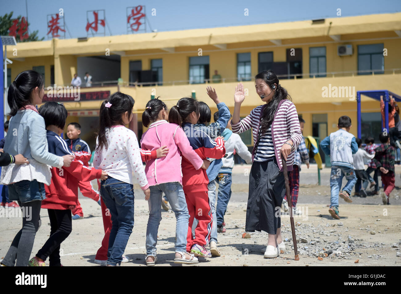 (160517) -- FENGTAI, 17 maggio 2016 (Xinhua) -- Li Yuanfang gioca con gli studenti a Zhangxiang Scuola Elementare di Dingji città di Fengtai County, est cinese della provincia di Anhui, 16 maggio 2016. Il 42-anno-vecchio insegnante femminile, che hanno sofferto la poliomielite in tre, ha mantenuto sulla classe che dà sul bastone per diciotto anni poiché la sua laurea nel 1998. Per anni ha riposare per almeno quattro ore ogni giorno, che rende i suoi afflitti da dolore in vita ed estremità inferiori. " Ho pensato che il mio corpo condizione potrebbe non fare di me un insegnante, ma finalmente ho trovato è molto significativo per me per portare la conoscenza t Foto Stock