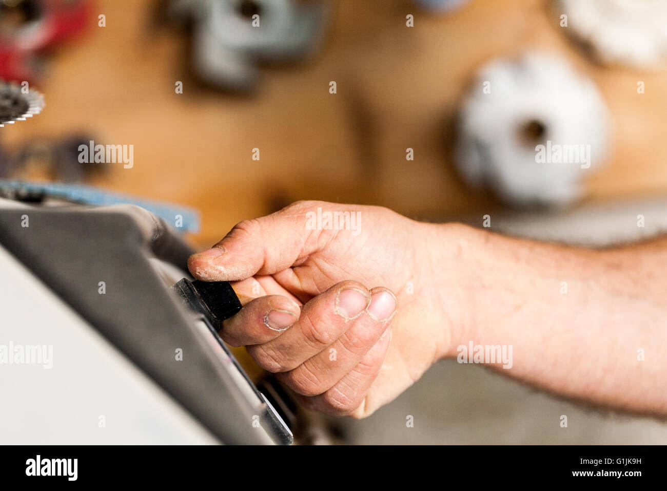 Mano di un falegname la commutazione su una macchina per lavori di falegnameria officina Foto Stock