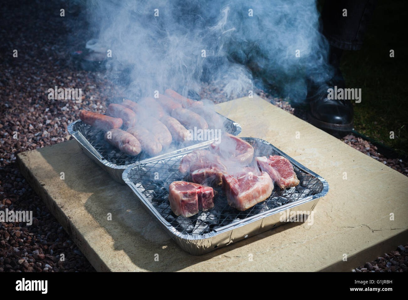La cottura della carne su un barbecue all'aperto durante la notte Foto Stock