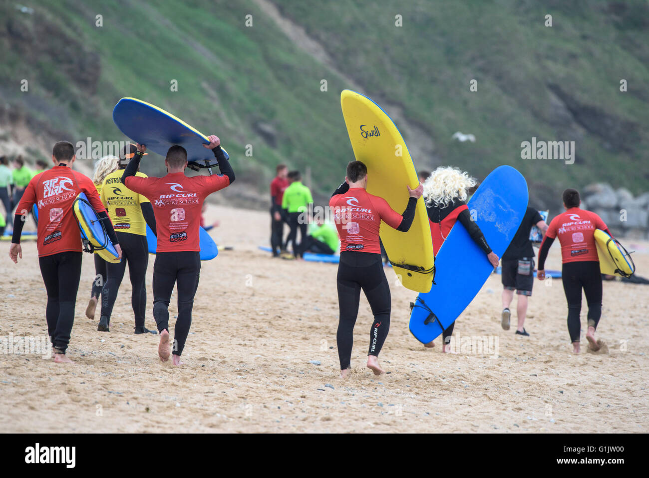 Principianti in procinto di iniziare la loro lezione di surf a Fistral, Newquay, Cornwall. Regno Unito. Foto Stock