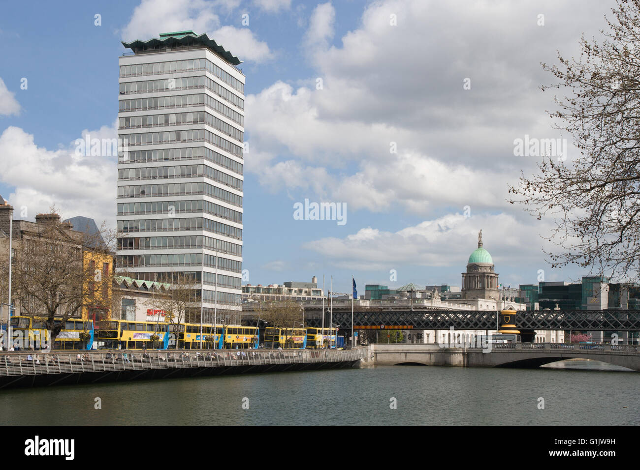 Irlanda, città di Dublino, Liberty Hall tower, grattacielo e la sede del SIPTU, giallo autobus turistici al fiume Liffey, cityscape Foto Stock