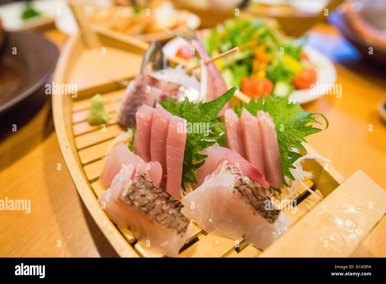 Giapponese pesce crudo tagliato di selezione e presentati su una piastra lunga Foto Stock