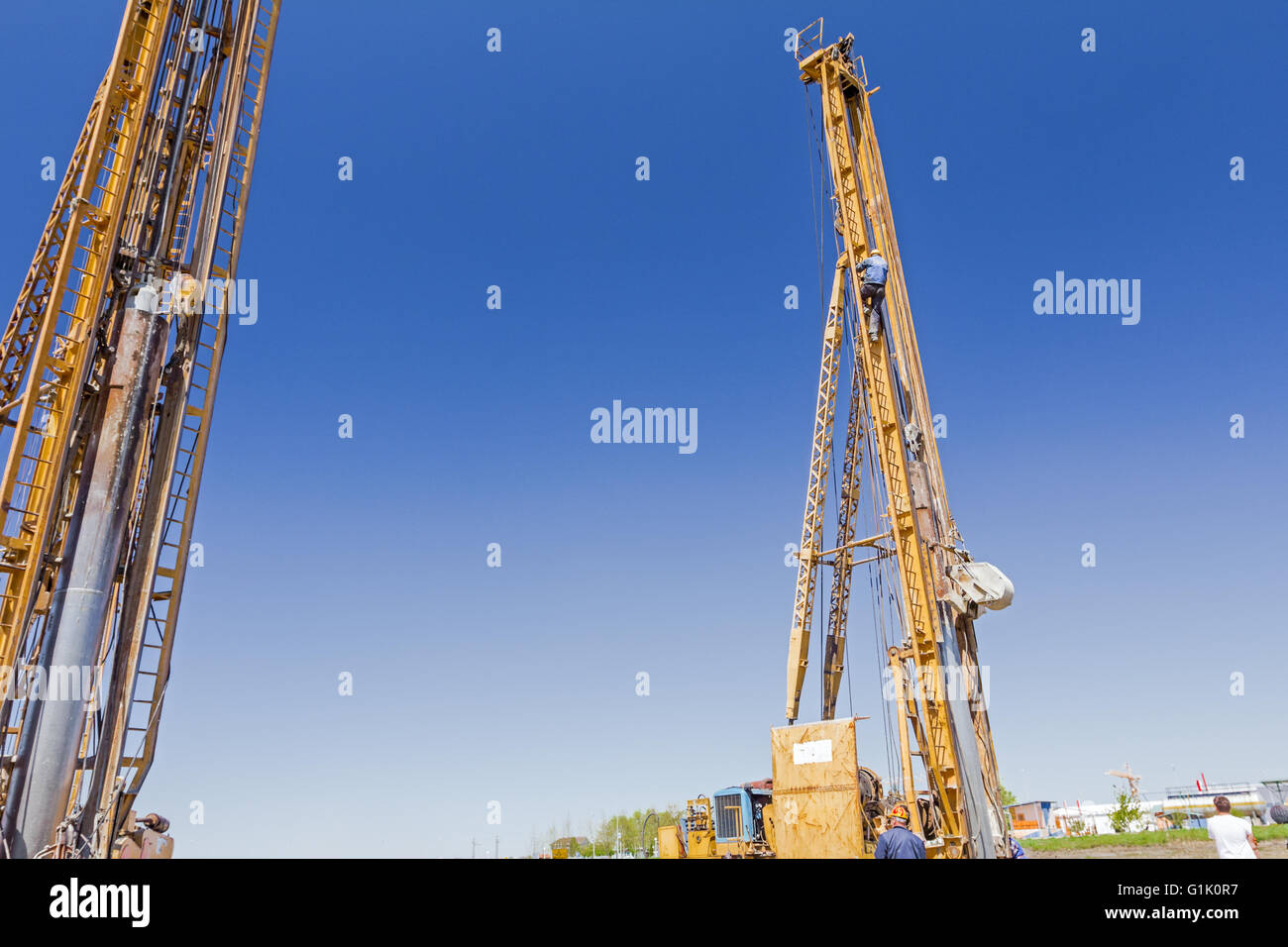 Lavoratore è arrampicata su scale e correzioni rinforzo nella torre di perforazione. Foto Stock